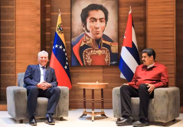Cuban President Miguel Díaz-Canel (left) and Venezuelan President Nicolás Maduro (right) with the country flags of their counterparts beside them and a drawing of Simón Bolívar in the background, during their meeting on Thursday, January 26. Photo: Presidential Press.