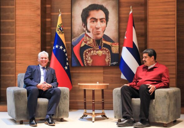 Cuban President Miguel Díaz-Canel (left) and Venezuelan President Nicolás Maduro (right) with the country flags of their counterparts beside them and a drawing of Simón Bolívar in the background, during their meeting on Thursday, January 26. Photo: Presidential Press.