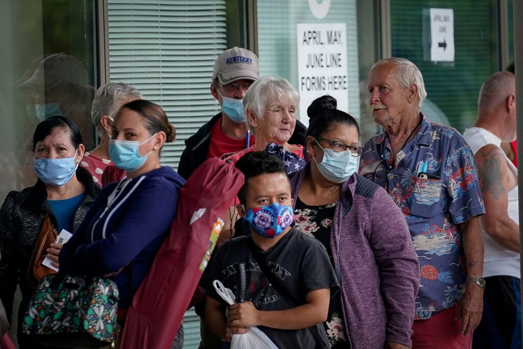 Masked adults line up outside a career center in Kentucky, US, hoping to find assistance with their unemployment claims. Photo: Reuters/Bryan Woolston.