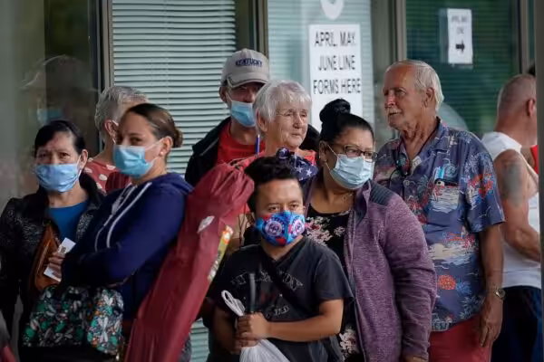 Masked adults line up outside a career center in Kentucky, US, hoping to find assistance with their unemployment claims. Photo: Reuters/Bryan Woolston.
