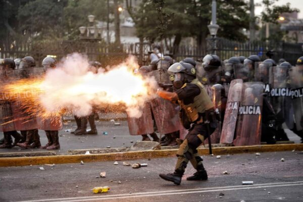 Peruvian police shooting at protesters in one of hundreds of rallies held across Peru demanding the end of the dictatorship imposed by the Congress since December 7. Photo: Antonio Melgarejo/EFE.