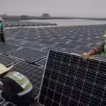Chinese workers prepare panels that will be part of a large floating solar farm project under construction by the Sungrow Power Supply Company on a lake caused by a collapsed and flooded coal mine on June 13, 2017 in Huainan, Anhui province, China. Photo: Kevin Frayer/Getty Images.