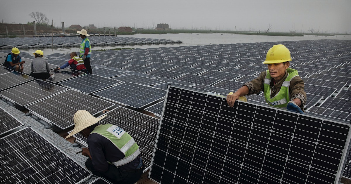 Chinese workers prepare panels that will be part of a large floating solar farm project under construction by the Sungrow Power Supply Company on a lake caused by a collapsed and flooded coal mine on June 13, 2017 in Huainan, Anhui province, China. Photo: Kevin Frayer/Getty Images.