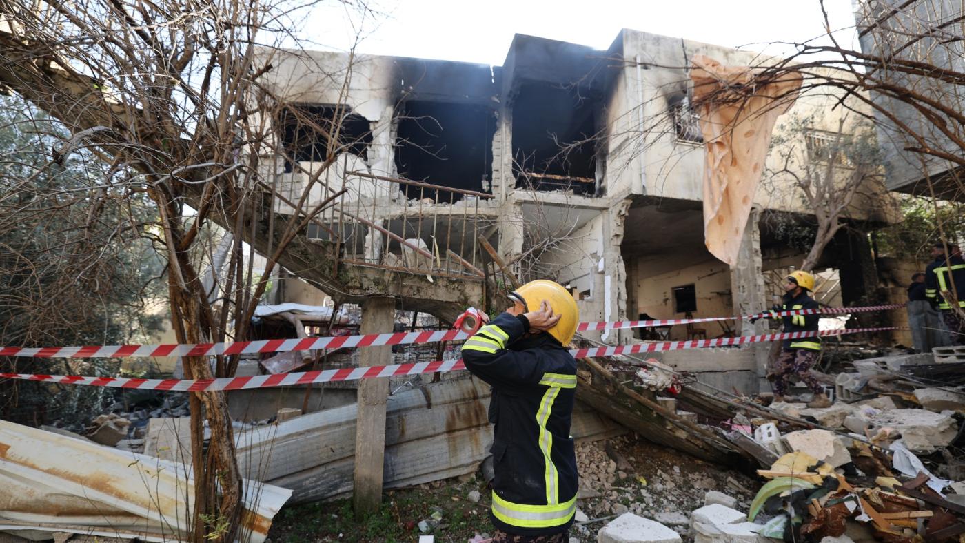 A first responder standing in front of a building heavily damaged by Israeli troops during a raid on the occupied West Bank's Jenin refugee camp. Photo: AFP. 
