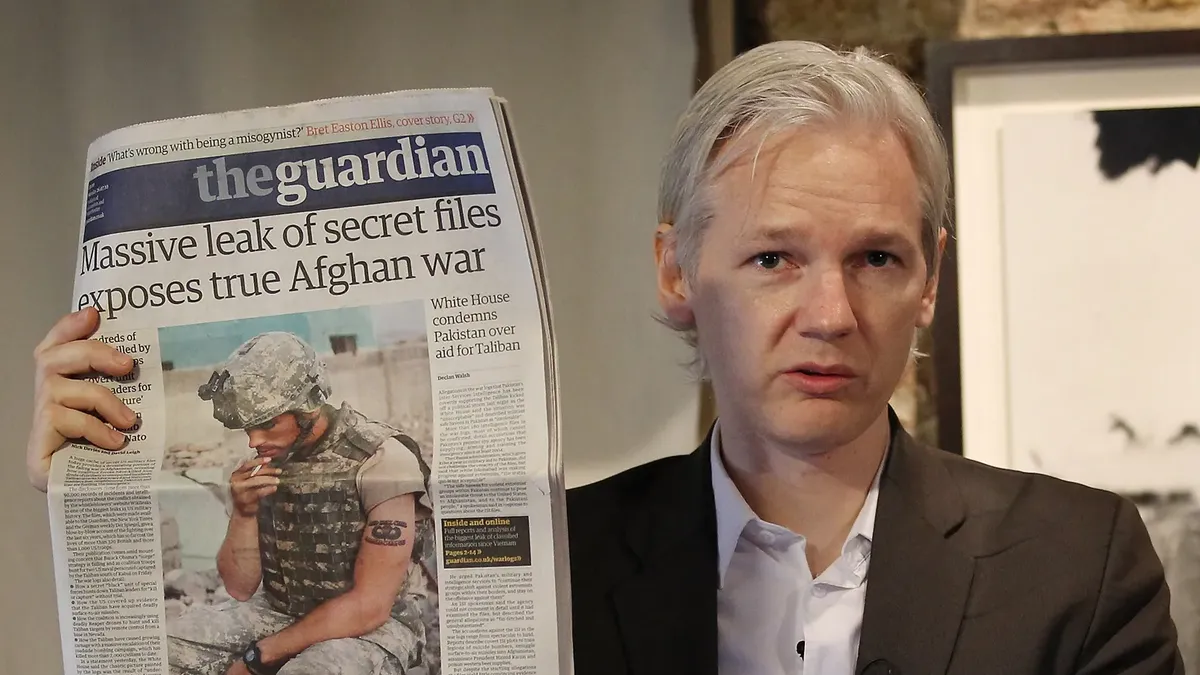 Julian Assange of WikiLeaks holds up a copy of The Guardian newspaper as he speaks to reporters on July 26, 2010 in London, England. Photo: Peter Macdiarmid/Getty Images.