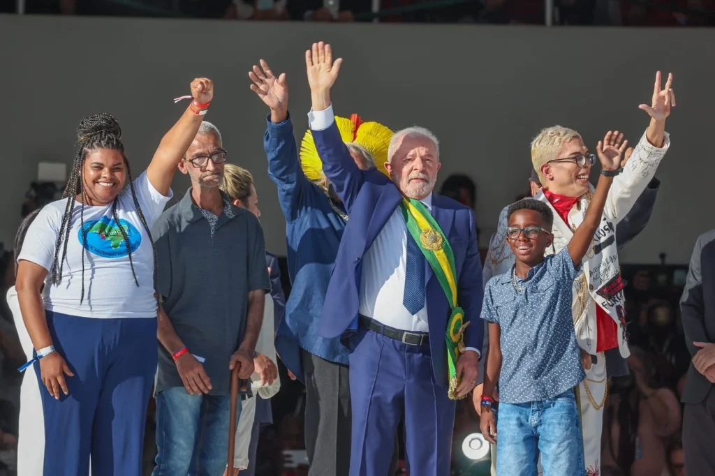 President Lula surrounded by ordinary Brazilians who passed him the presidential sash as Jair Bolsonaro abandoned his presidential duty to do so and escaped to the United States less than 48 hours before his legal immunity expired. Photo: Ricardo Stuckert/Gazeta Esportiva.