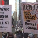 Antiwar protest in New York City and a close up to two banners. The first on the left reads "No war with Russia for Wall Street" and the second (right) reads "U.S./NATO, No war on Russia & Donbass, Stop NATO, Disband NATO now." Photo: Struggle La Lucha.