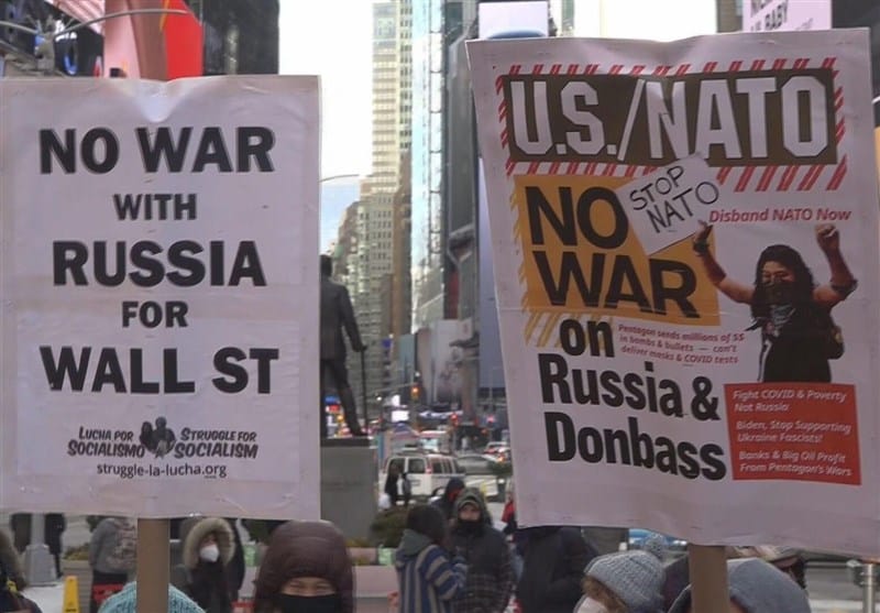 Antiwar protest in New York City and a close up to two banners. The first on the left reads "No war with Russia for Wall Street" and the second (right) reads "U.S./NATO, No war on Russia & Donbass, Stop NATO, Disband NATO now." Photo: Struggle La Lucha.