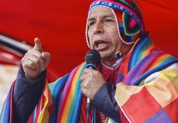 Peruvian President Pedro Castillo wearing an indigenous hat and a Wipala flag draped over his shoulders. Photo: Carlos Mamani/AFP/FIle photo.