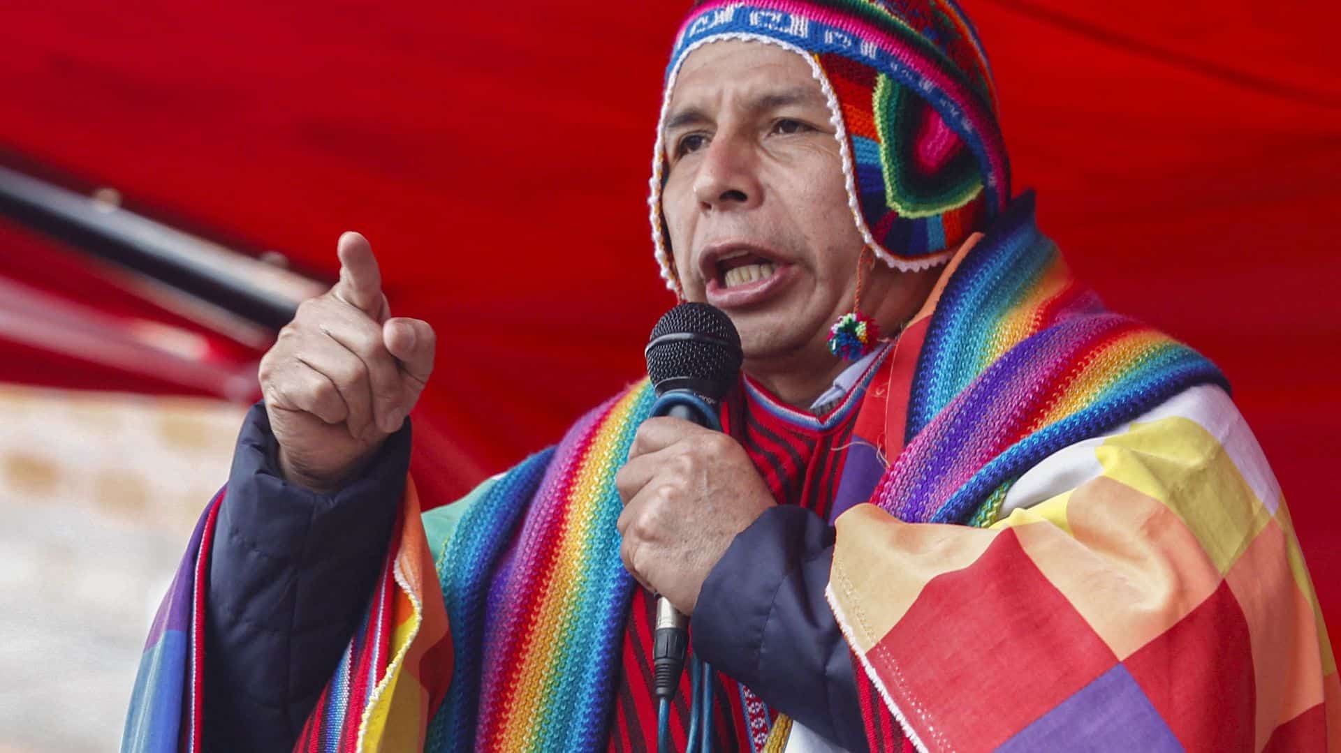 Peruvian President Pedro Castillo wearing an indigenous hat and a Wipala flag draped over his shoulders. Photo: Carlos Mamani/AFP/FIle photo.
