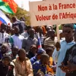People hold a sign as they gather to show their support to Burkina Faso's new military leader Ibrahim Traore and demand the departure of the French ambassador at the Place de la Nation in Ouagadougou, Burkina Faso January 20, 2023. The sign reads: "France's army get out of our country." Photo: Vincent Bado/Reuters.