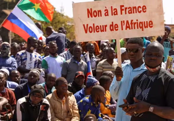 People hold a sign as they gather to show their support to Burkina Faso's new military leader Ibrahim Traore and demand the departure of the French ambassador at the Place de la Nation in Ouagadougou, Burkina Faso January 20, 2023. The sign reads: "France's army get out of our country." Photo: Vincent Bado/Reuters.