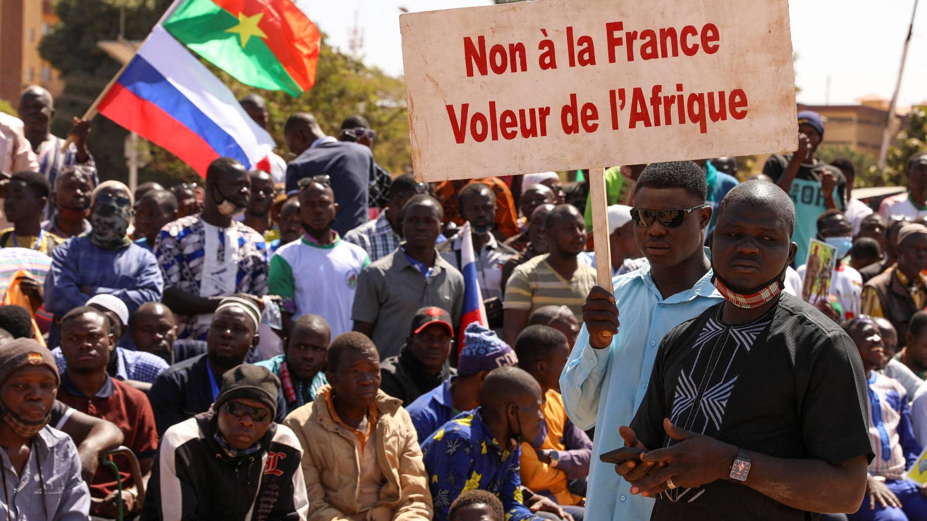 People hold a sign as they gather to show their support to Burkina Faso's new military leader Ibrahim Traore and demand the departure of the French ambassador at the Place de la Nation in Ouagadougou, Burkina Faso January 20, 2023. The sign reads: "France's army get out of our country." Photo: Vincent Bado/Reuters.