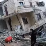 Residents stand in front of a collapsed building following an earthquake in the town of Jindires, located in the northern Syrian countryside in Afrin district, Aleppo province. Photo: Rami al Sayed/AFP via Getty Images.