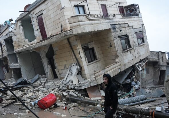 Residents stand in front of a collapsed building following an earthquake in the town of Jindires, located in the northern Syrian countryside in Afrin district, Aleppo province. Photo: Rami al Sayed/AFP via Getty Images.