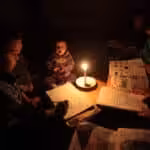 A palestinian family sits inside their makeshift house during power cuts in Khan Younis in the Southern Gaza strip march 15, 2014. Photo: Ashraf Amra/APA images.