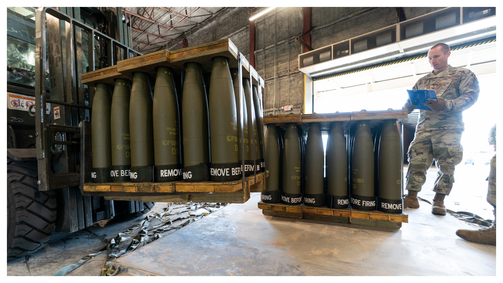 A U.S. Air Force staff sergeant checks pallets of 155 mm shells ultimately bound for Ukraine, at Dover Air Force Base, U.S., April 29, 2022. Photo: AFP.