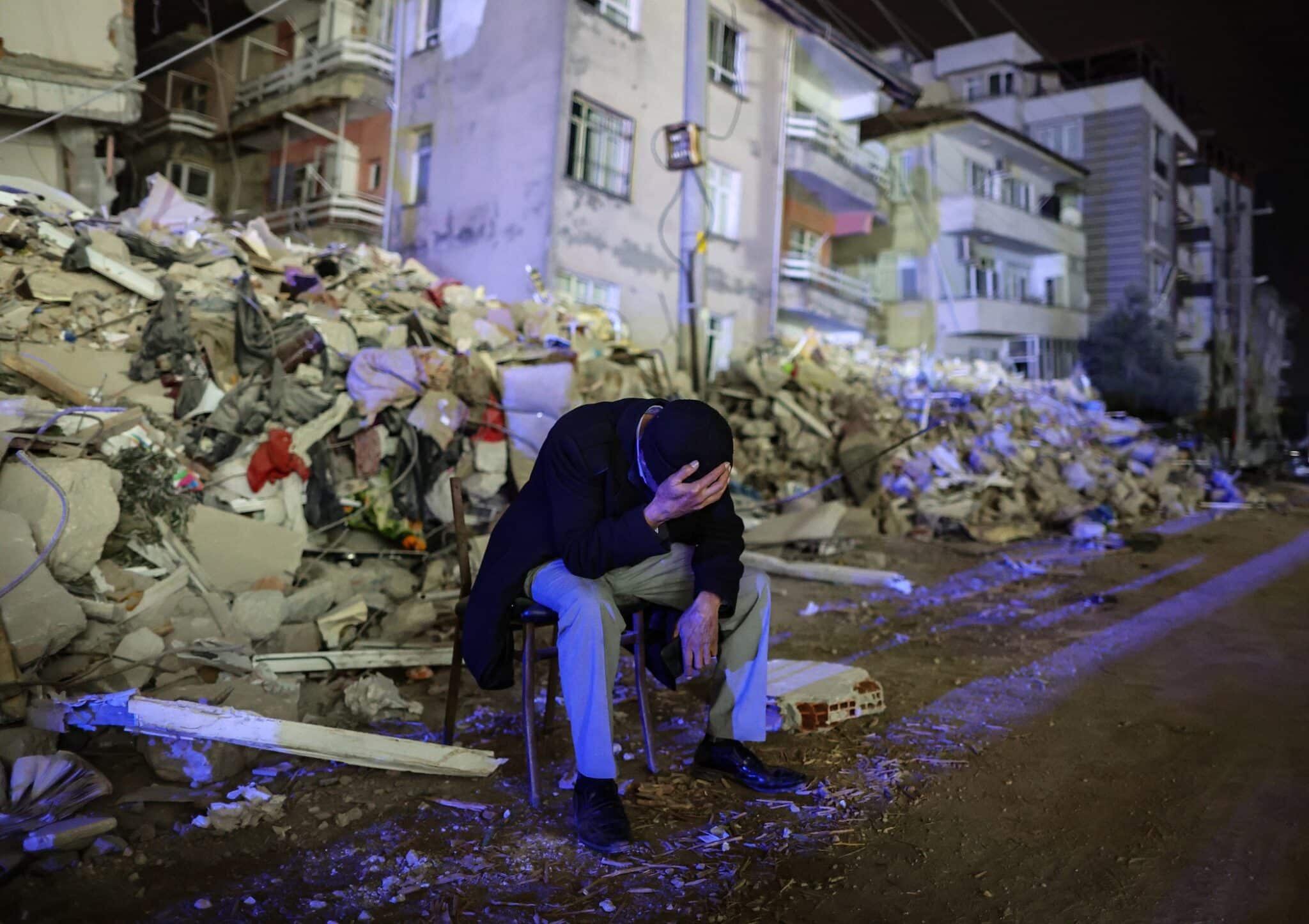 An elderly man sits amongst rubble after a 6.3 magnitude earthquake in Hatay, Türkiye, on February 20, 2023. Photo: Erdem Sahin/EPA-EFE/Shutterstock.