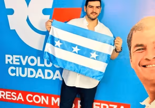 Advertisement of the Revolución Ciudadana party where a person holds a flag and in a strip at the bottom it reads : "return with more strength" and on the right side can be seen former president Rafael Correa smiling. File photo.