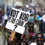 Demonstrator in Haiti holding a banner that reads "where is the Petrocaribe money?" Photo: Misión Verdad.