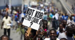 Demonstrator in Haiti holding a banner that reads "where is the Petrocaribe money?" Photo: Misión Verdad.