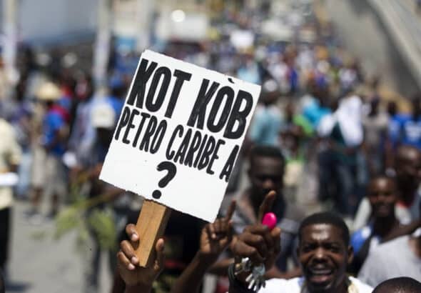 Demonstrator in Haiti holding a banner that reads "where is the Petrocaribe money?" Photo: Misión Verdad.
