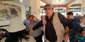 Screenshot of the video circulating on social media platforms about the incident, showing the Peruvian Vice Minister Henry Rebaza covering his face while being protected by a security agent. Photo: social media platforms, video screenshot.