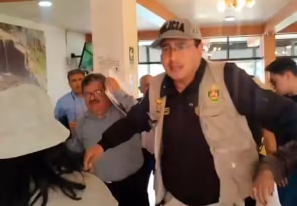 Screenshot of the video circulating on social media platforms about the incident, showing the Peruvian Vice Minister Henry Rebaza covering his face while being protected by a security agent. Photo: social media platforms, video screenshot.