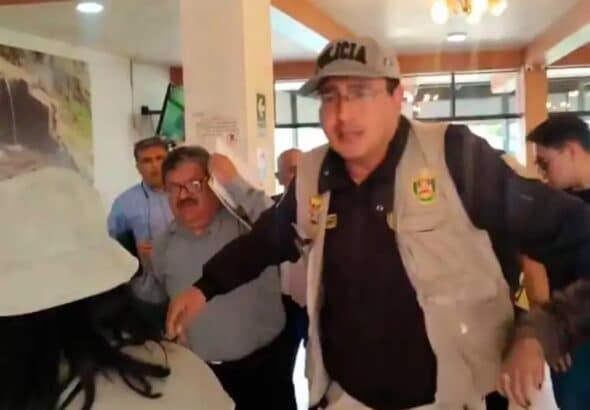 Screenshot of the video circulating on social media platforms about the incident, showing the Peruvian Vice Minister Henry Rebaza covering his face while being protected by a security agent. Photo: social media platforms, video screenshot.