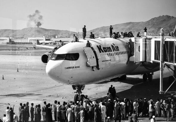 Afghans storming the Kabul Airport days before US Army's abandonment of the country. Photo: Wakil Kohsar/AFP.