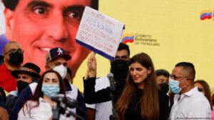 Camilla Fabri, the wife of Venezuelan diplomat Alex Saab, holds up a banner demanding freedom for the abducted diplomat. She is accompanied by supporters, with a picture of Saab's face in the background. Photo: File photo.