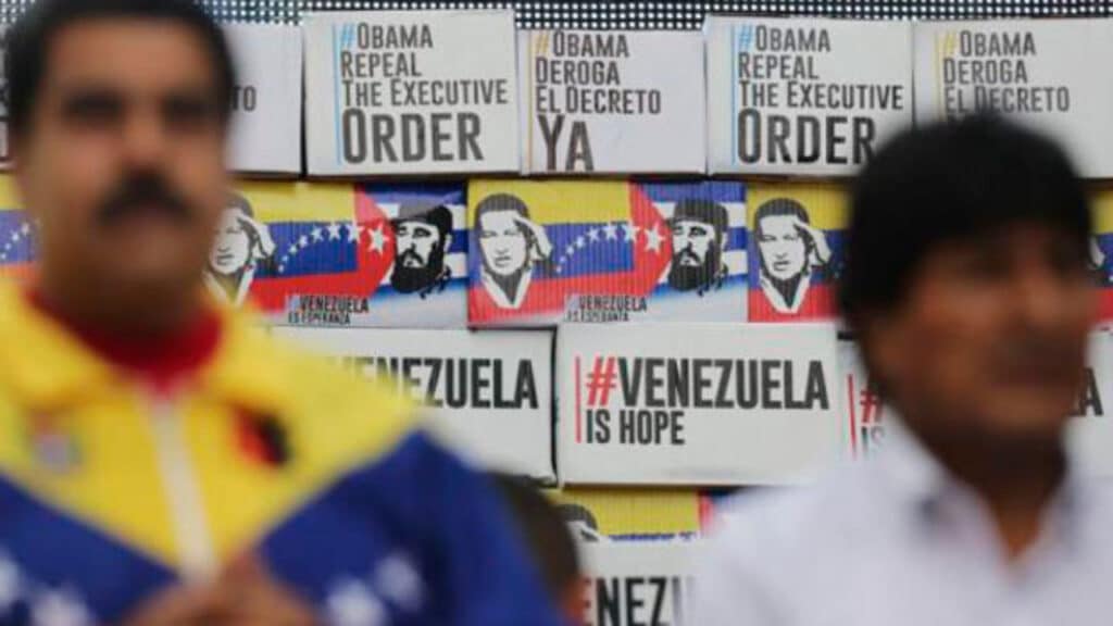 Venezuelan President Nicolás Maduro (left) and former Bolivian President Evo Morales (right), with a wall in the background with banner captioning "#ObamaRepealTheExecutiveOrder," "#ObamaDerogaElDecretoYa," "#VenezuelaIsHope," during a ceremony when more that 13 million signatures were collected rejecting the White House decision declaring Venezuela an "unusual and extraordinary threat" to US security, Caracas, April 2015. Photo: File photo.