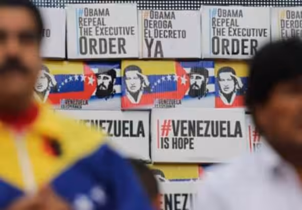 Venezuelan President Nicolás Maduro (left) and former Bolivian President Evo Morales (right), with a wall in the background with banner captioning "#ObamaRepealTheExecutiveOrder," "#ObamaDerogaElDecretoYa," "#VenezuelaIsHope," during a ceremony when more that 13 million signatures were collected rejecting the White House decision declaring Venezuela an "unusual and extraordinary threat" to US security, Caracas, April 2015. Photo: File photo.
