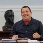 Featured image: Commander Hugo Chávez smiling while sitting in front of a statue of Simón Bolívar. Photo: Twitter/@NicolasMaduro.