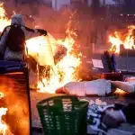 Trash cans burning in Paris, France, as protests continue in the country against the government's pension reform. Photo: AP/Jean-Francois Badias.