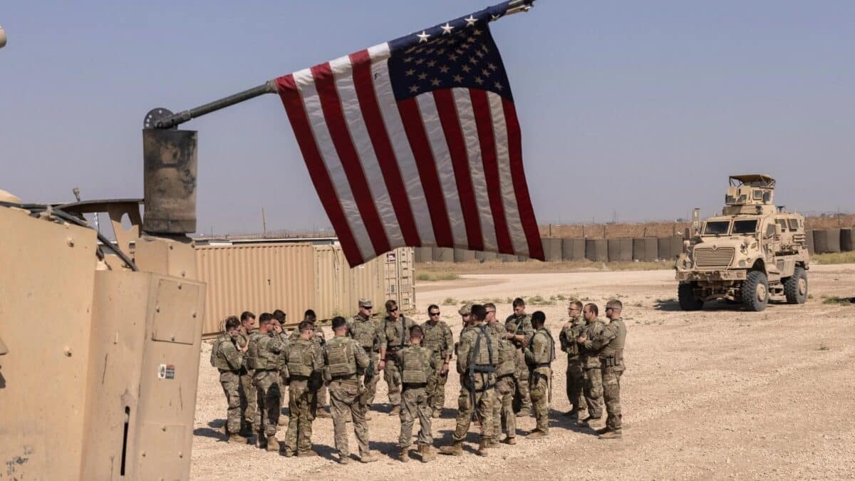 US occupation force in Syria gathered below a US flag. Photo: Getty Images.