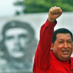 President Hugo Chavez raising his hand with a clenched fist and in the background a photo of Che. Photo: File photo.
