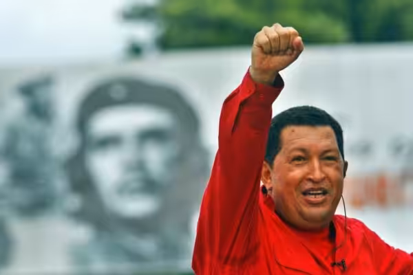 President Hugo Chavez raising his hand with a clenched fist and in the background a photo of Che. Photo: File photo.