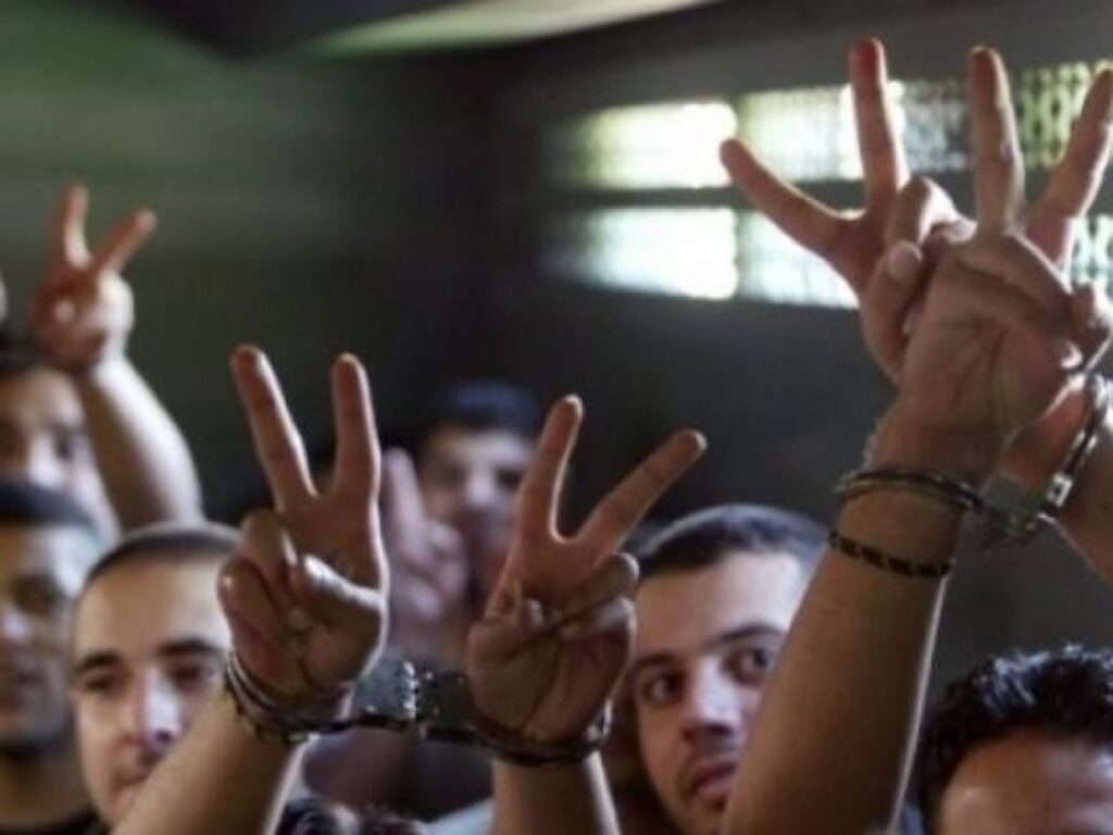 Handcuffed Palestinian prisoners show the victory sign. File photo.