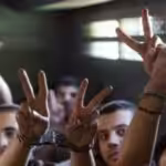 Handcuffed Palestinian prisoners show the victory sign. File photo.