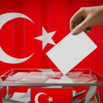 Illustration of a ballot box with a person casting a vote, with the Turkish flag in the background. Photo: Twitter/@eevriviade.