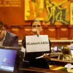 A woman holds a piece of paper that reads "Lasso On Trial" in the National Assembly of Ecuador, this Saturday, March 25, 2023. Photo: Karen Toro/Reuters.