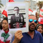 Demonstrators carry Lebanese flags and a banner depicting Lebanon's central bank governor, Riad Salameh, as they head towards the central bank building during an anti-government protest in the southern city of Tyre, Lebanon. Photo: Aziz Taher/Reuters.