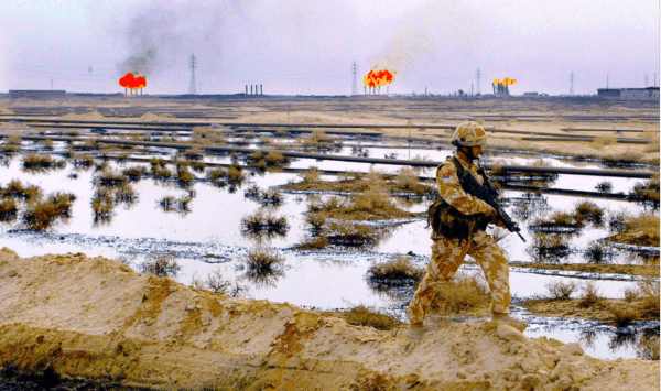 A British soldier patrols the Rumaila oil field in southern Iraq, 1 February 2005. BP was awarded the contract to be lead operator of the field four years later. Photo: Andrew Parsons/AFP via Getty.
