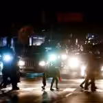 Residents cross a street during the power outage in Caracas, Venezuela. The act of sabotage left crowds of commuters in the capital city were walking home after metro service ground to a halt, and traffic snarled as motorists struggled to navigate intersections where traffic lights were out. Photo: Eduardo Verdugo/AP.