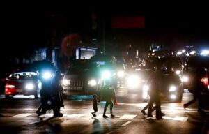 Residents cross a street during the power outage in Caracas, Venezuela. The act of sabotage left crowds of commuters in the capital city were walking home after metro service ground to a halt, and traffic snarled as motorists struggled to navigate intersections where traffic lights were out. Photo: Eduardo Verdugo/AP.
