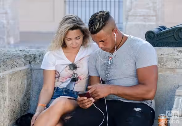 A couple uses a mobile phone to surf the internet in Havana. Photo: Kaloian/Archive.
