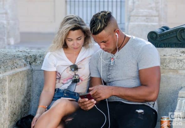 A couple uses a mobile phone to surf the internet in Havana. Photo: Kaloian/Archive.