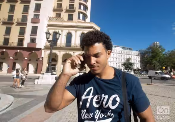 A young man talking on a cell phone in the street. Photo: Otmaro Rodriguez.