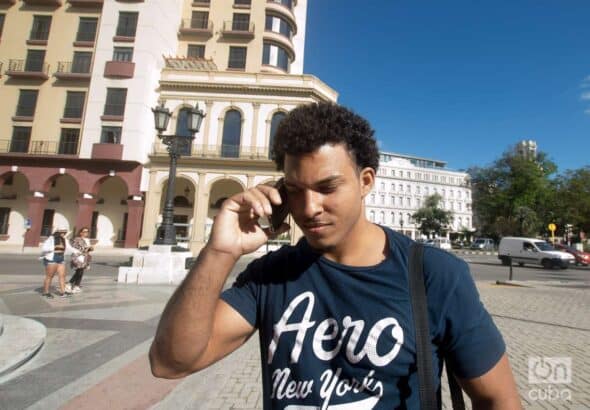 A young man talking on a cell phone in the street. Photo: Otmaro Rodriguez.